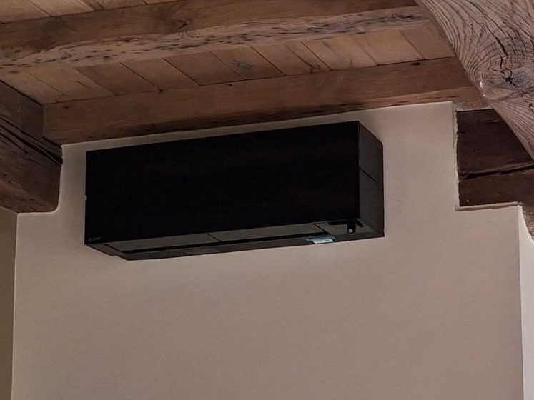 Binnenunit airco in een afgewerkte woonkamer, hele ruimte zichtbaar